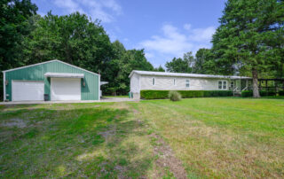 Front view of 3-bedroom lake home with large metal garage shop at 8828 Oakland Road in Oakland, Arkansas near Bull Shoals Lake.