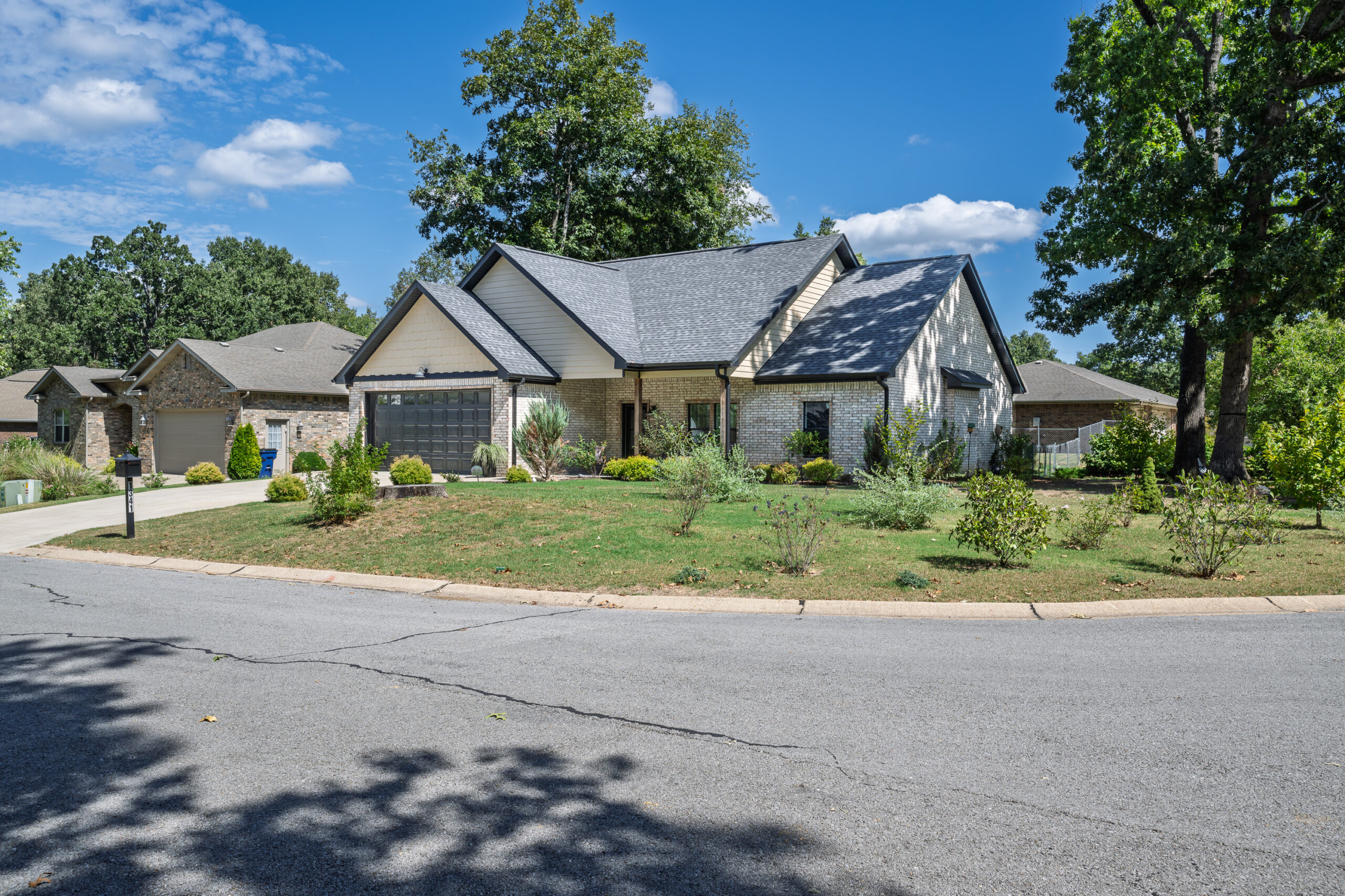 Front exterior of the brick home at 1341 Hampshire Circle in Mountain Home, Arkansas, with an attached garage and landscaped front yard.